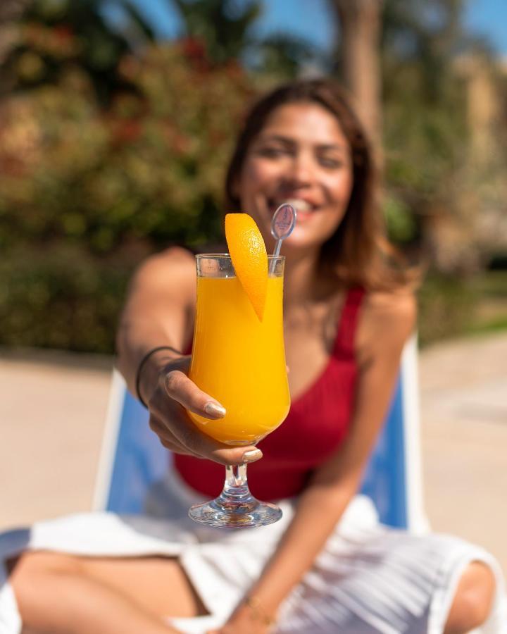 Grand Ocean El Sokhna Hotel Ain Sukhna Bagian luar foto A woman holding a mango lassi