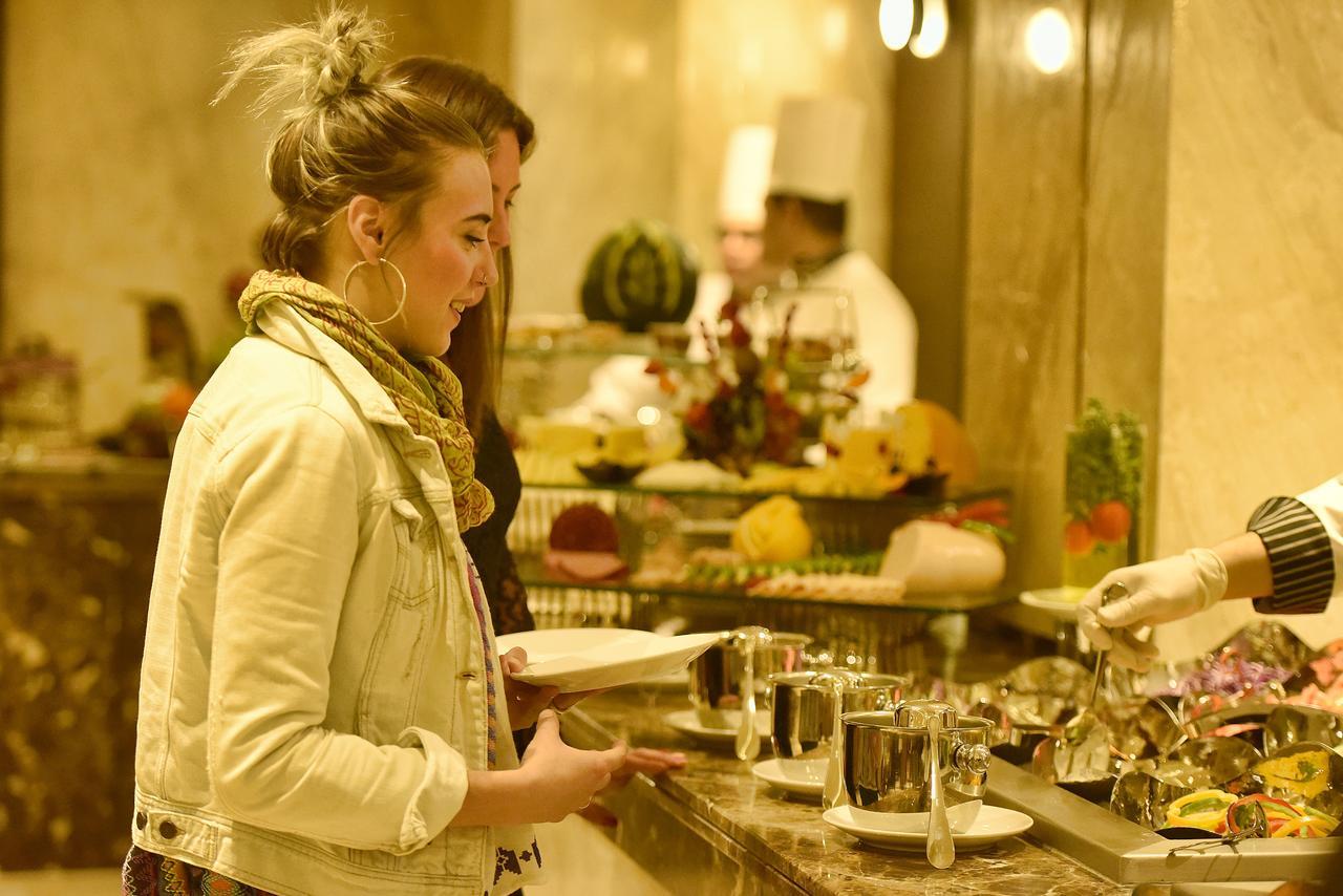 Grand Ocean El Sokhna Hotel Ain Sukhna Bagian luar foto A woman selecting food from a buffet